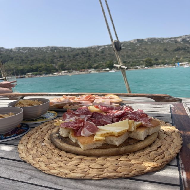 Cagliari: Boat Tour with Swim Stops, Snorkeling, & Aperitif - Onboard vibe: wine, music, and a real Sardinian tasting