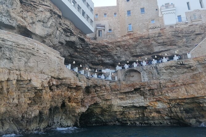 Monopoli Shared tour by Gozzo boat to the Polignano caves - The statue and the song: Polignano’s sea-facing tribute