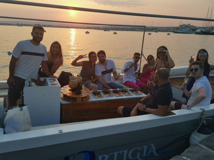 Syracuse: Ortigia Sunset Cruise with Aperitif - Sunset hour: music, shoreline glow, and passing Umbertino Bridge